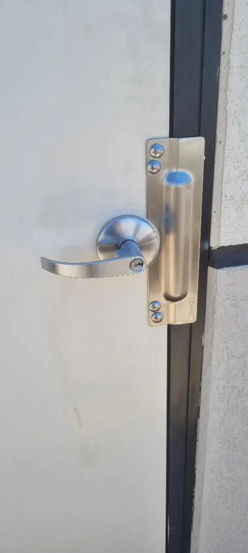 Commercial lever lock with stainless anti-jemmy blocker plate fitted to an external door in Perth