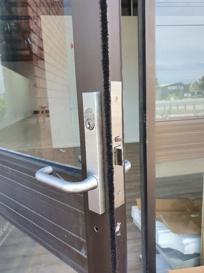New mortice lock and lever handle installed on a commercial aluminium shopfront door in Perth