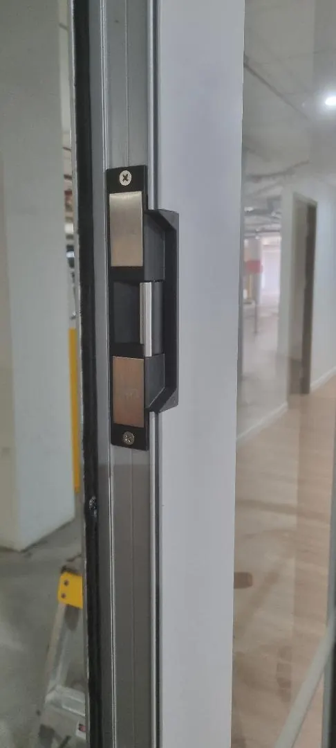 Electric strike fitted to an aluminium glass partition door during a Perth office fit-out