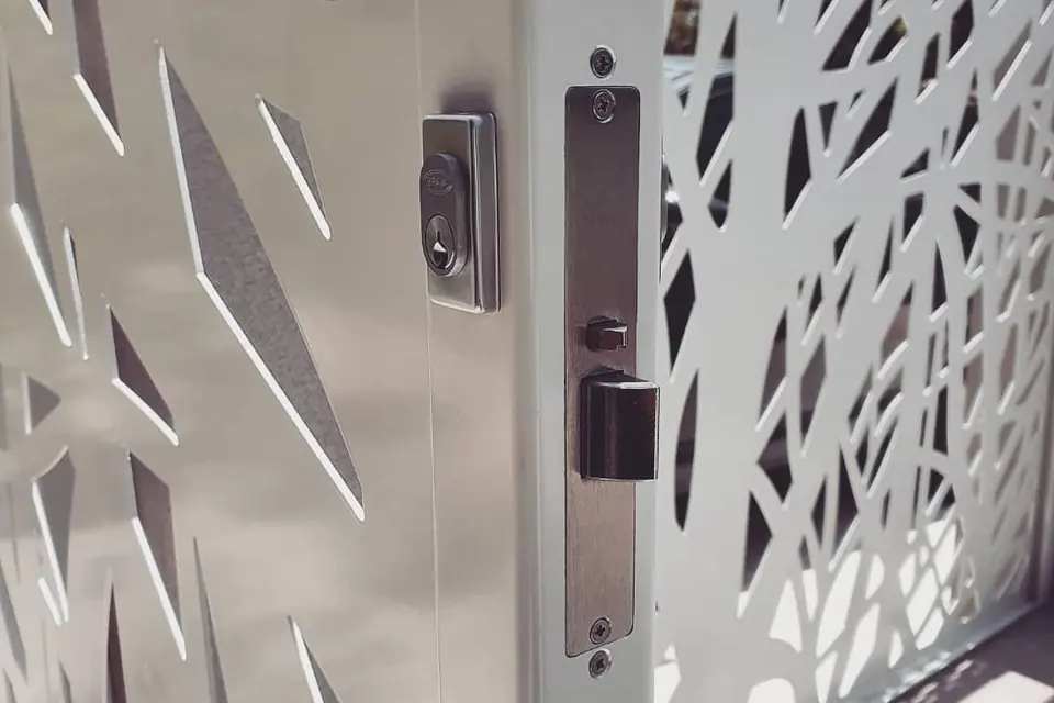 Keyed gate lock installed on a white laser-cut decorative aluminium gate in Perth
