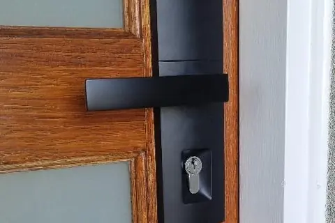 Matte black lever entrance lockset installed on a timber front door in Perth