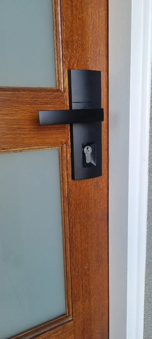 Matte black lever entrance lockset installed on a timber front door in Perth